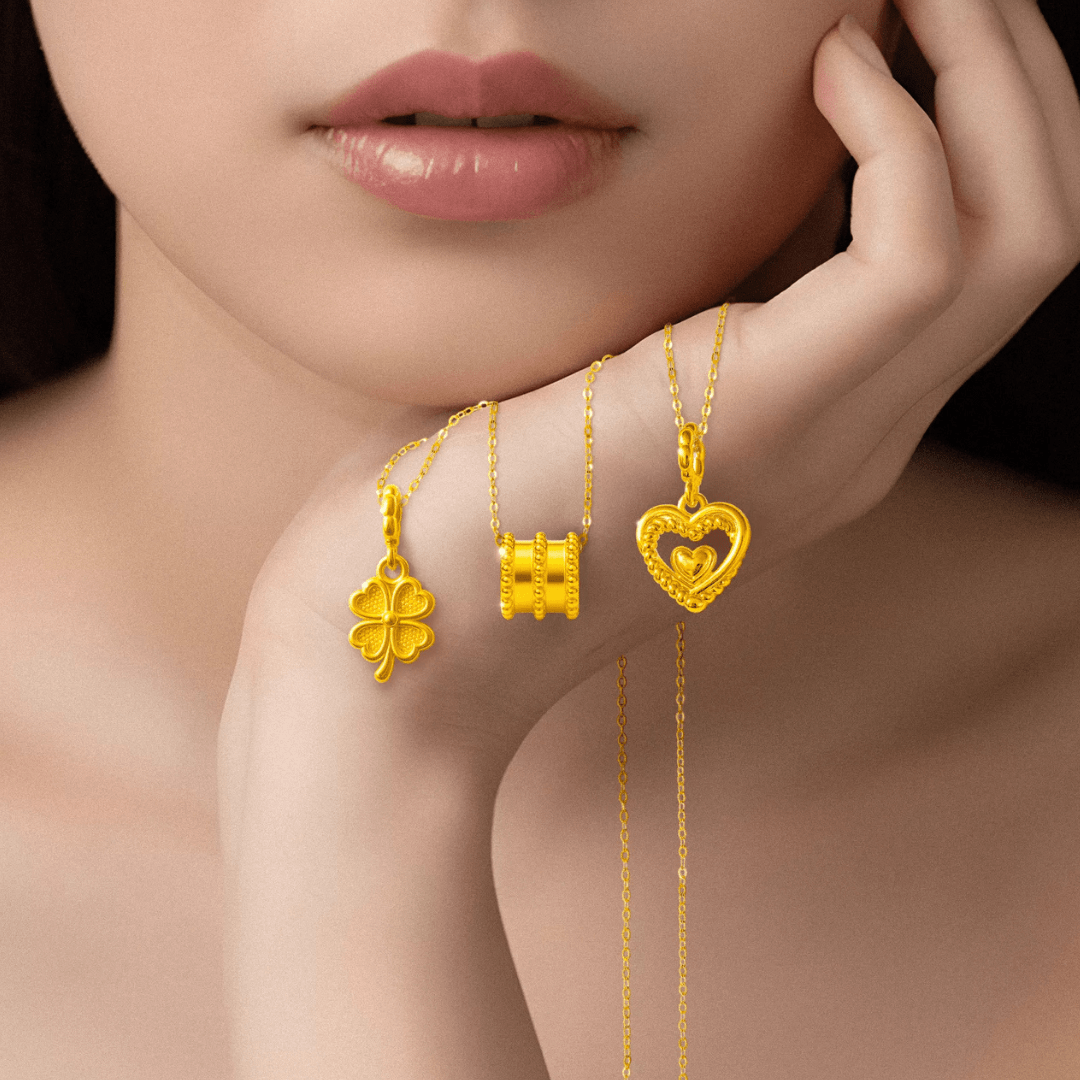 A model holding a heart-shaped pendant, clover-shaped pendant, and barrel-shaped pendant
